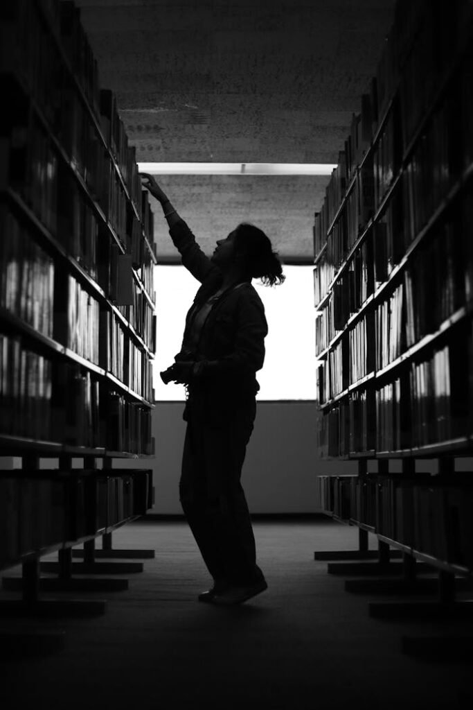 A person is standing in a library with books